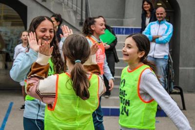Des collégiennes et une joueuse de l'Olympique de Marseille échangent des high-fives avec enthousiasme après une session sportive, illustrant l'esprit d'équipe et la joie du partage. - Agrandir l'image 3 sur 16, fenêtre modale