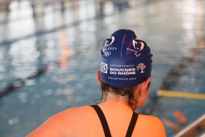 Nageur en bonnet bleu Paris 2024 au bord d'une piscine intérieure, prêt à plonger. - Agrandir l'image 4 sur 8, fenêtre modale