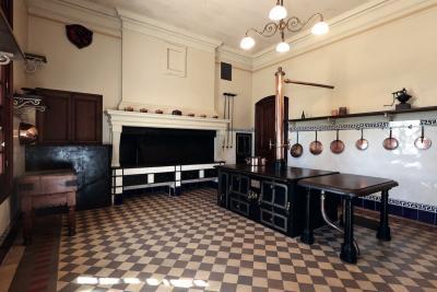 une belle cuisine avec damier de tommette au sol; jeu de casserole en cuivre au mur et fourneau noir au centre de la pièce - Agrandir l'image 2 sur 6, fenêtre modale