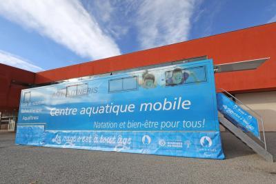 Camion bleu Centre Aquatique Mobile garé devant un bâtiment rouge. Il s'agit d'un camion piscine du Département des Bouches-du-Rhône - Agrandir l'image 8 sur 8, fenêtre modale
