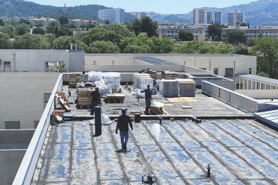 Vue du toit du collège Gyptis (Marseille, 9e). Les ouvriers travaillent à l'isolation. - Agrandir l'image 4 sur 4, fenêtre modale