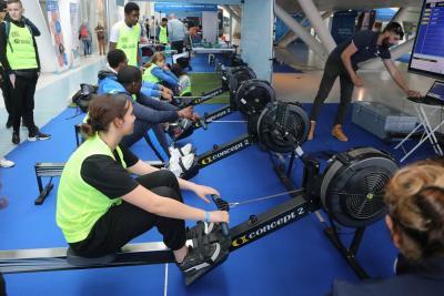 Des ados sont alignés les uns contre les autres sur des machines de rameurs. - Agrandir l'image 9 sur 9, fenêtre modale