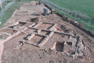 Vestiges de murs en pierre formant des pièces rectangulaires sur un site archéologique, avec engins de chantier à proximité - Agrandir l'image 5 sur 5, fenêtre modale