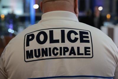 Un adulte vu de dos porte un polo blanc avec l’inscription “POLICE MUNICIPALE” en grands caractères bleu marine. Il se trouve dans un espace intérieur éclairé, avec d’autres personnes en uniforme autour, suggérant un rassemblement institutionnel. Il s'agissait de la cérémonie des voeux au personnel des forces de l'ordre et de secours des Bouches-du-Rhône. - Agrandir l'image 6 sur 18, fenêtre modale