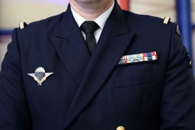 Un adulte en uniforme bleu marine porte une veste cérémoniale avec une cravate noire, un insigne métallique ailé et un ensemble de décorations colorées. L’image est centrée sur le torse. L’arrière‑plan montre un intérieur aux tons clairs, l'ambiance est institutionnelle, il s'agit d'une cérémonie officielle, la cérémonie des voeux au personnel des forces de l'ordre et de secours des Bouches-du-Rhône. - Agrandir l'image 8 sur 18, fenêtre modale