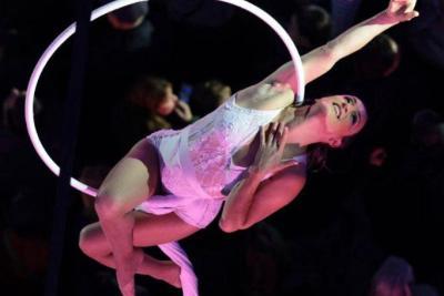 Artiste aérienne suspendue à un cerceau, effectuant une figure acrobatique au-dessus du public - Agrandir l'image 10 sur 20, fenêtre modale