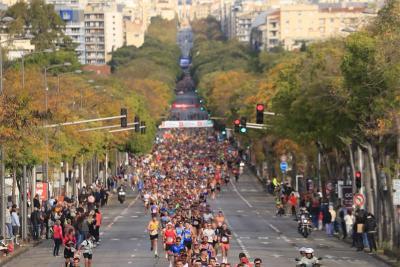 Grande foule de coureurs participant au semi-marathon Marseille-Cassis sur une large avenue bordée d’arbres, avec la ville et les collines en arrière-plan. - Agrandir l'image 2 sur 12, fenêtre modale
