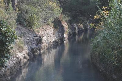 Canal étroit bordé de roches et de végétation, avec de l’eau calme reflétant les arbres environnants. - Agrandir l'image 3 sur 4, fenêtre modale