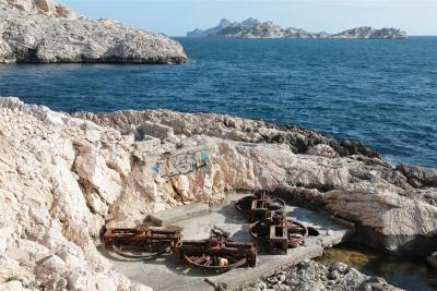 Vue des rochers en bord de mer. On devine les restes rouillés de l'installation du téléscaphe : 4 roues qui permettaient d'actionner les câbles. - Agrandir l'image 1 sur 5, fenêtre modale