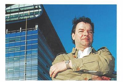 William Alsop, les bras croisés, se tient devant l'Hôtel du Département, un bâtiment qu'il a conçu en 1994. Le ciel bleu en arrière-plan met en valeur l'architecture moderne de la structure. - Agrandir l'image 2 sur 3, fenêtre modale