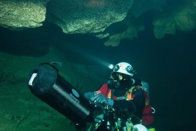 Plongeur sous la roche avec casque et bouteille portant un long appareil en main - Agrandir l'image 1 sur 6, fenêtre modale